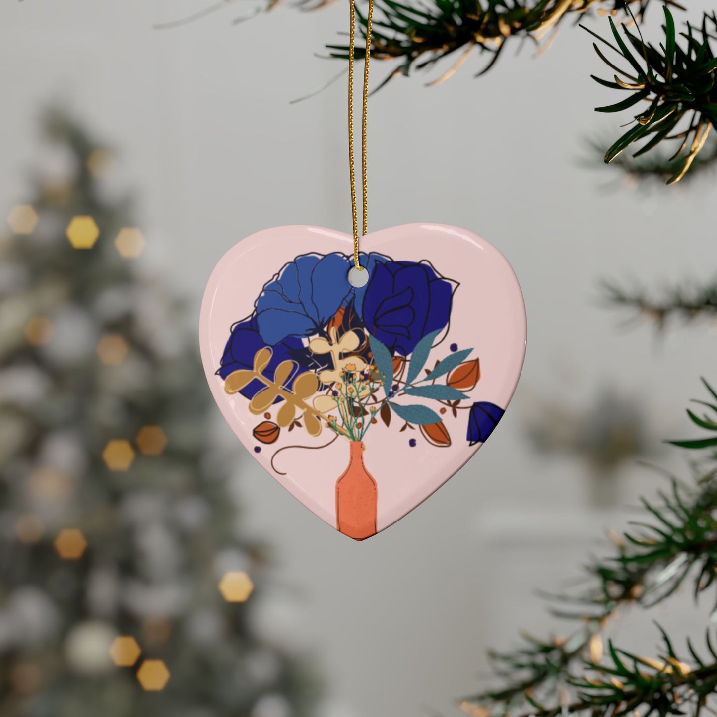 Heart-shaped decorative ornament with floral design hanging on a tree branch.